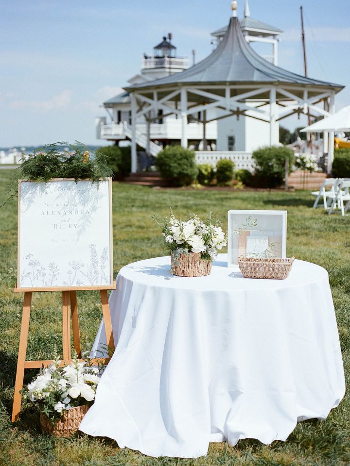 Welcome table with white florals and greenery.
