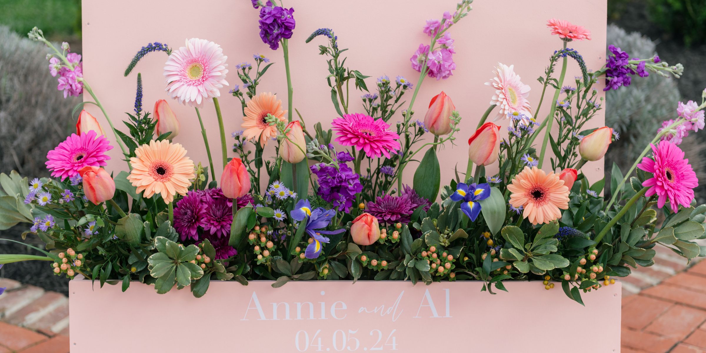 Jewel tone spring florals in a welcome sign box.