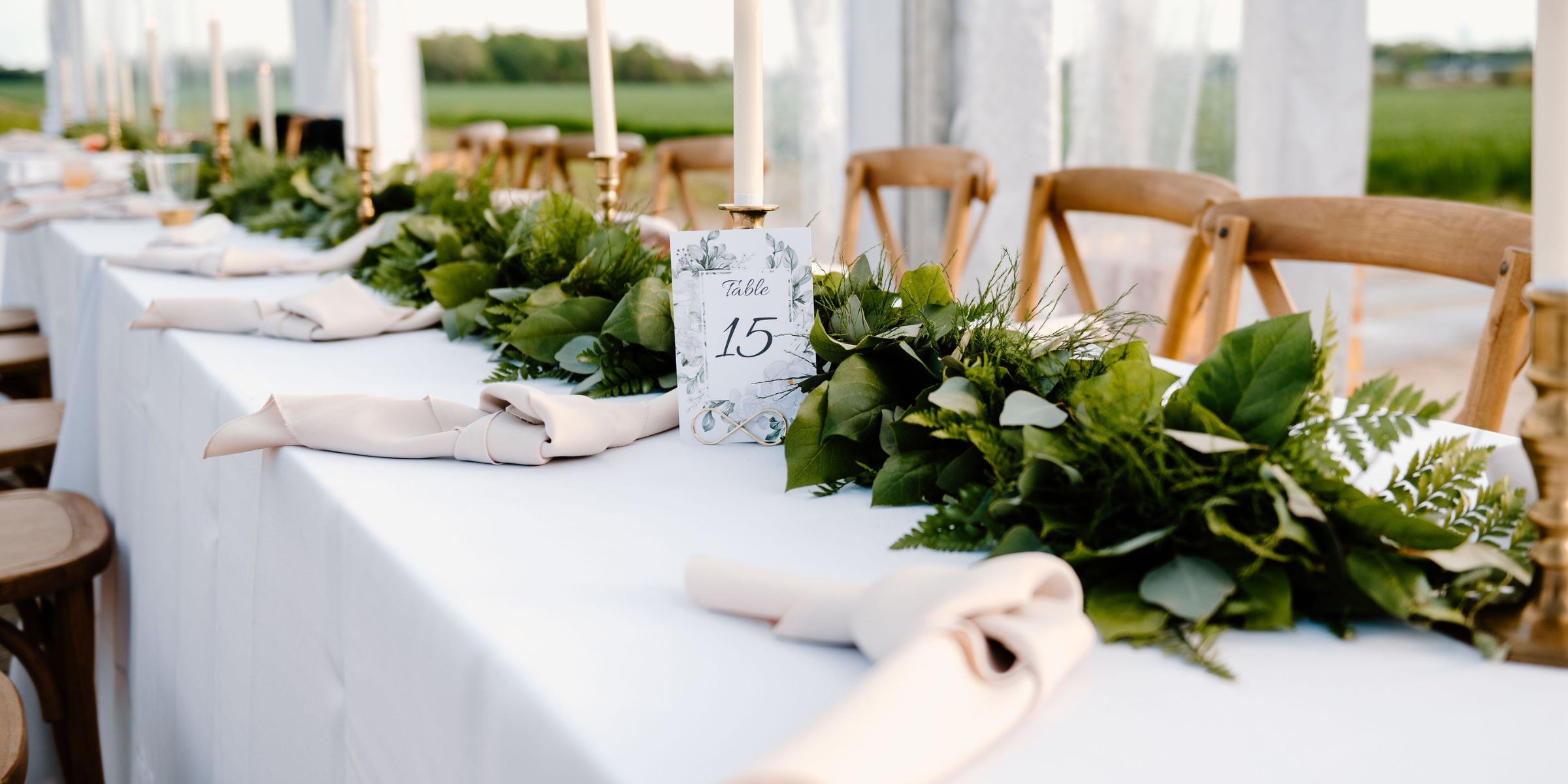 Spring greenery garland on long rectangular table at wedding reception.