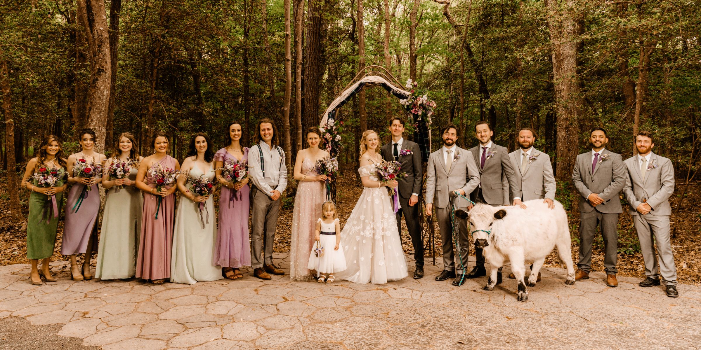Bride and Groom stand in center of line of wedding party.