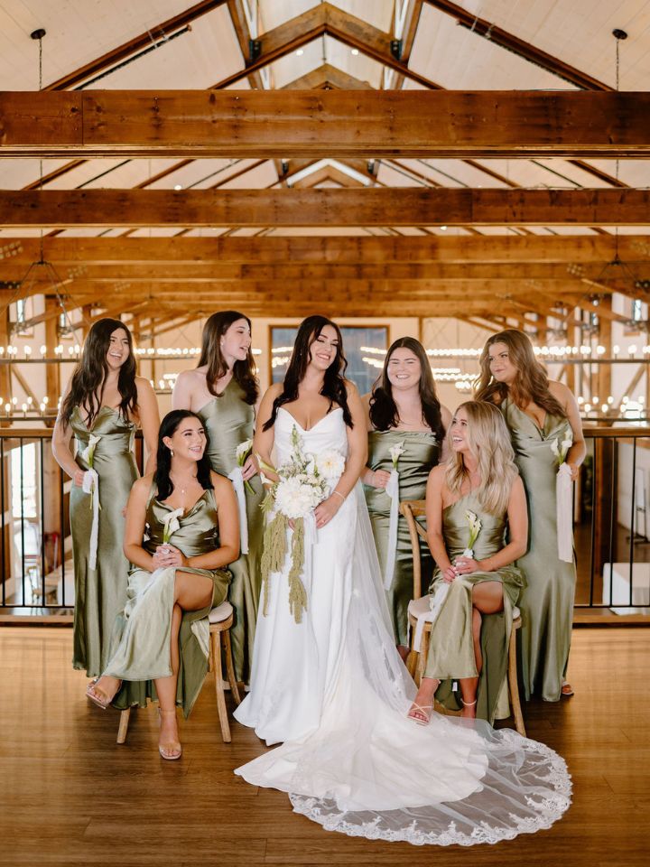Bride and bridesmaids pose with calla lily bouquets.