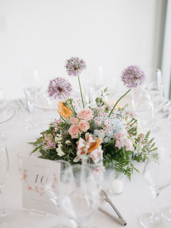 Round table floral centerpiece with purple allium.