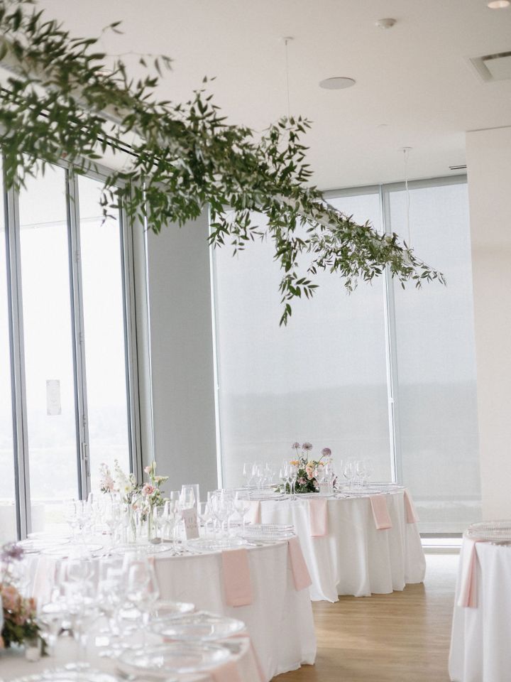 Greenery on lights in a restaurant wedding reception.