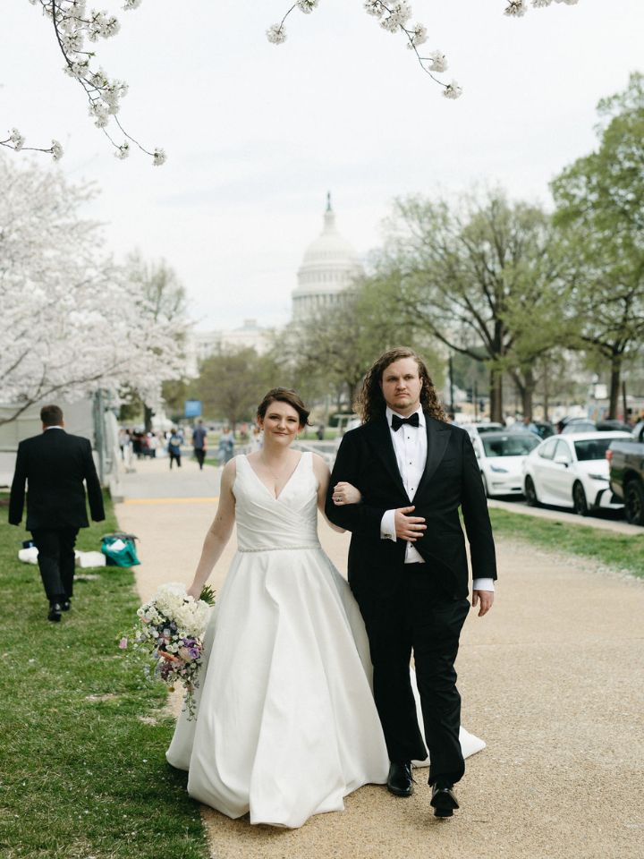Bride and groom walk down sidewalk in DC.