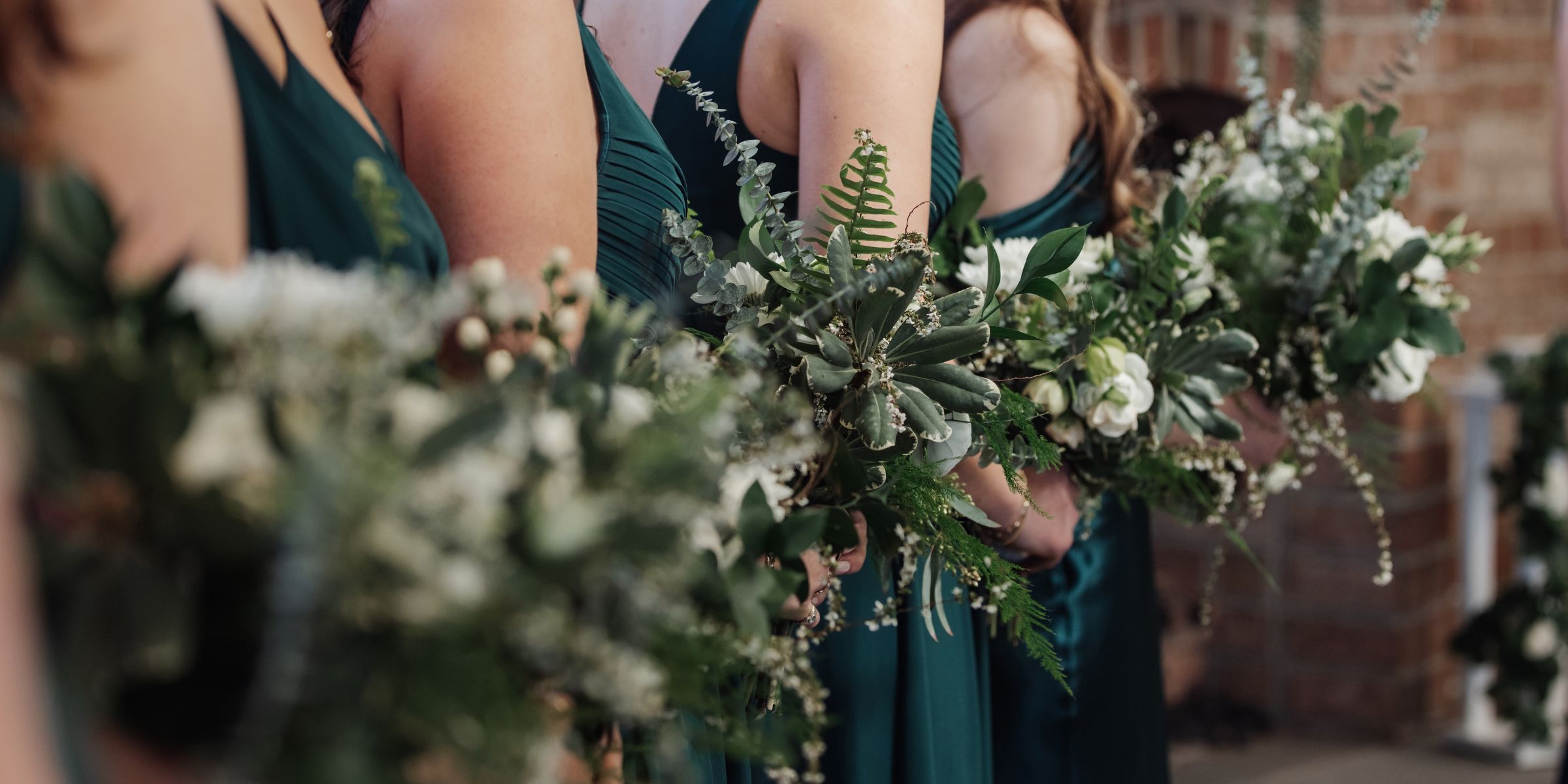 Closeup of bridesmaid bouquets, lined up at ceremony.