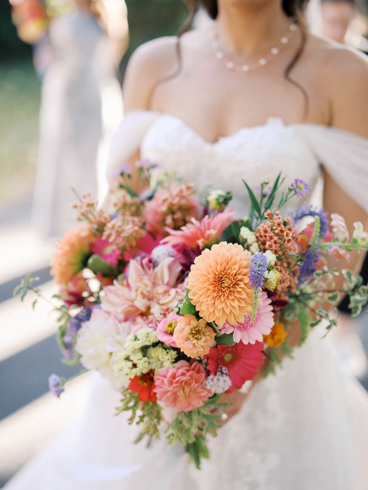 Closeup of bridal bouquet with dahlias, zinnias, and fall flowers.