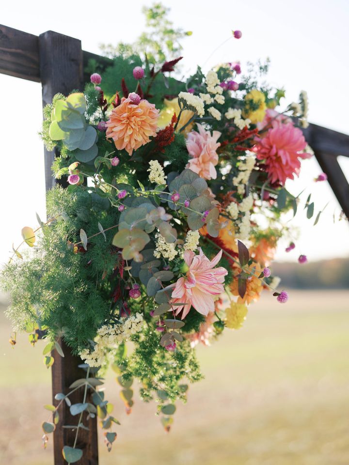 Detail of flower arrangement on wooden ceremony arch.