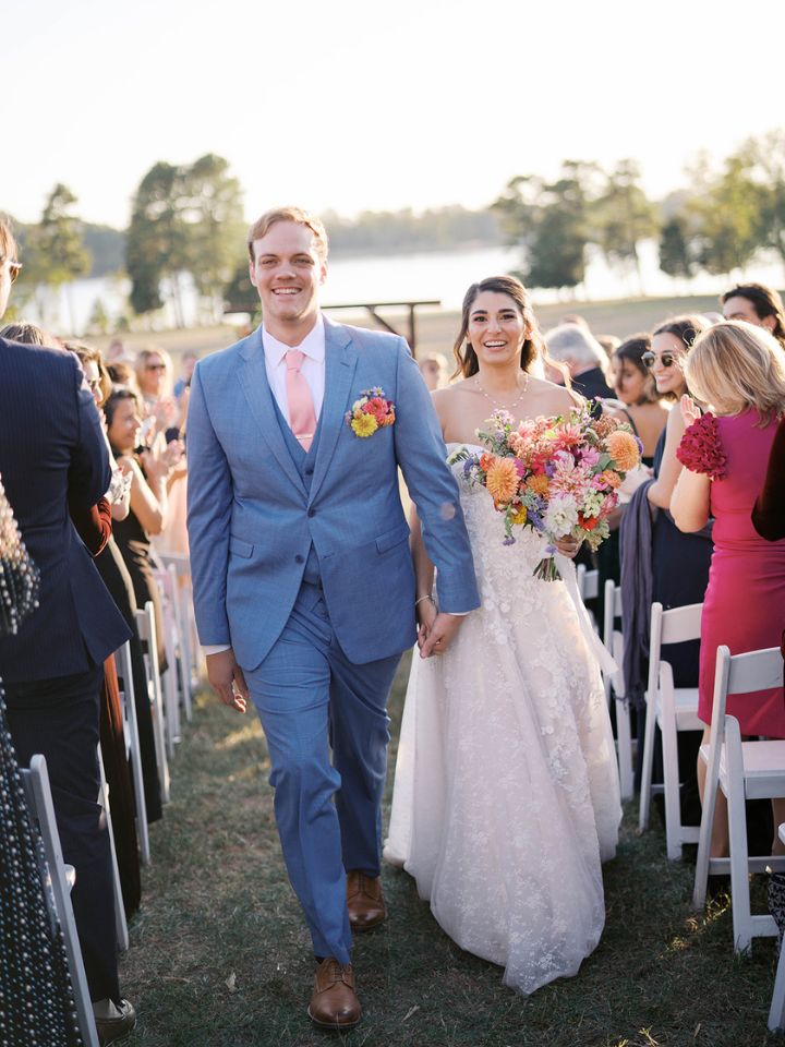 Bride and groom walk back up aisle after ceremony at a colorful Brittland wedding in October.