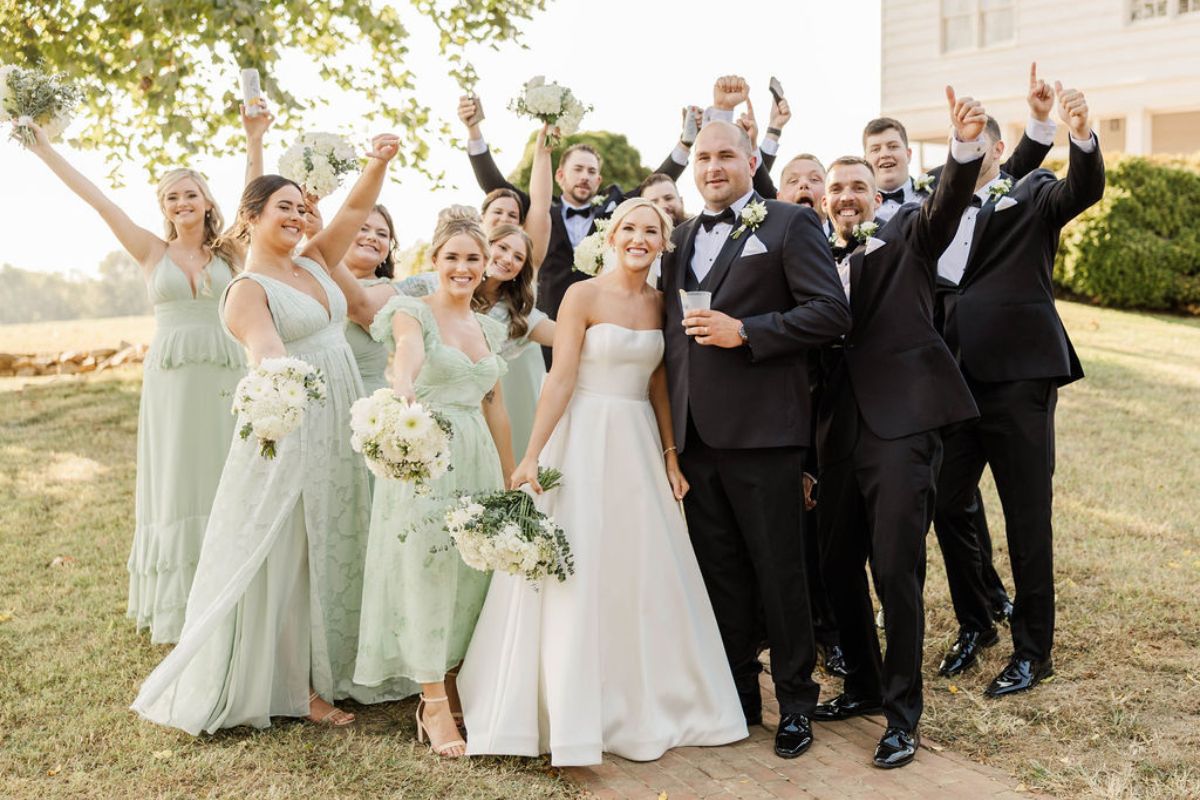 Wedding party cheers on couple.