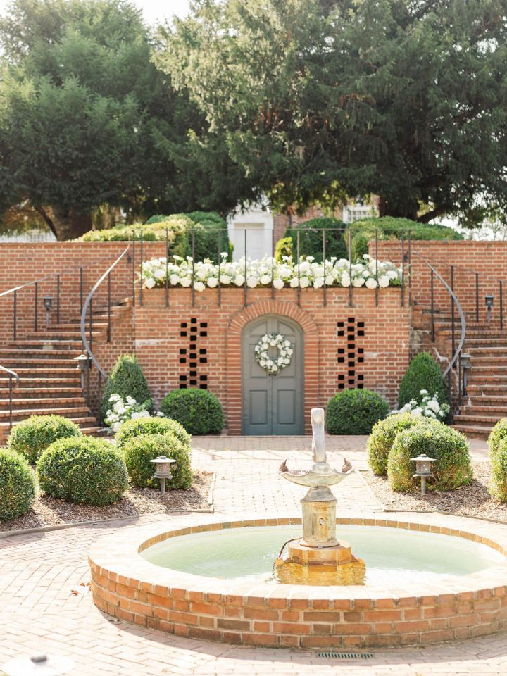 Brick garden staircase with white flower arrangements for wedding ceremony.