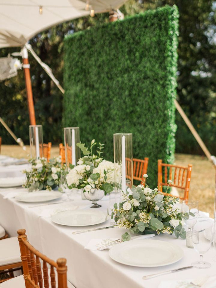 Head table with white and green flower arrangements.
