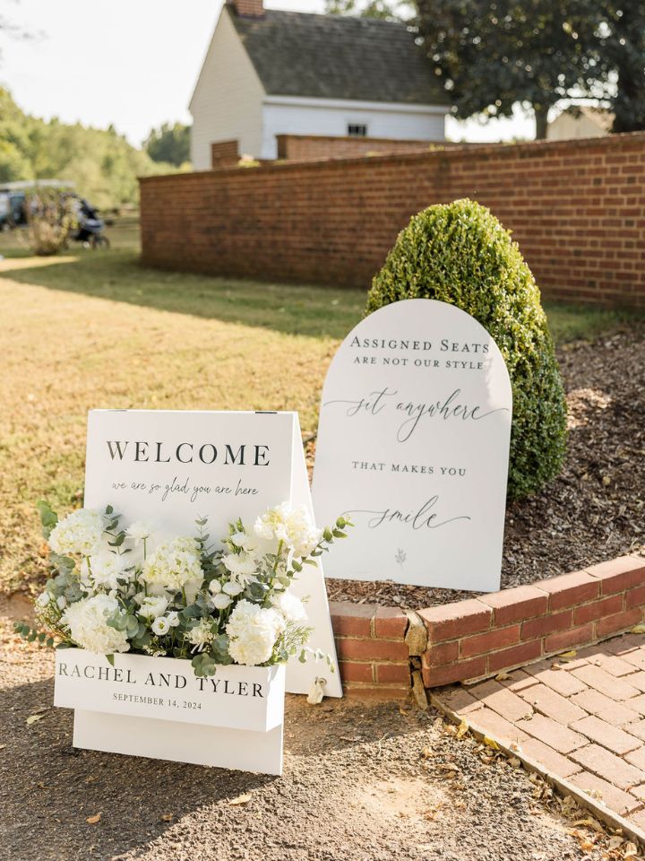 Welcome box sign with white flowers.