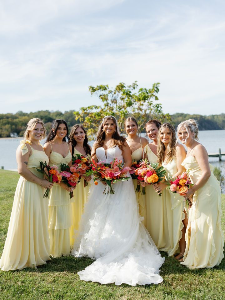 Bride and bridesmaids pose with bouquets.