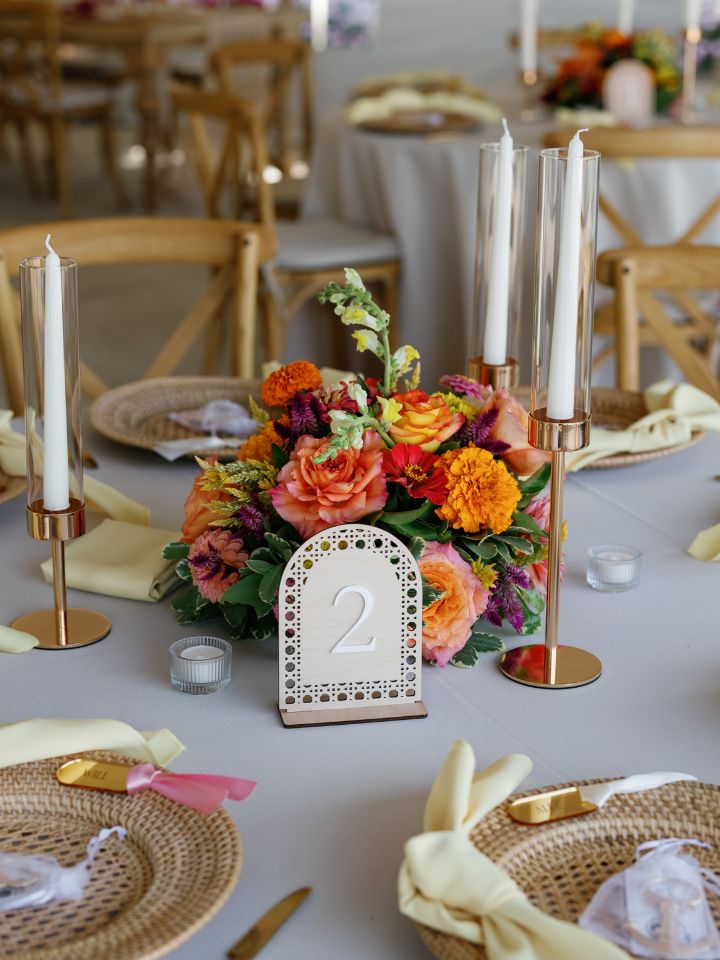 Flower centerpiece on round table with taper candles.