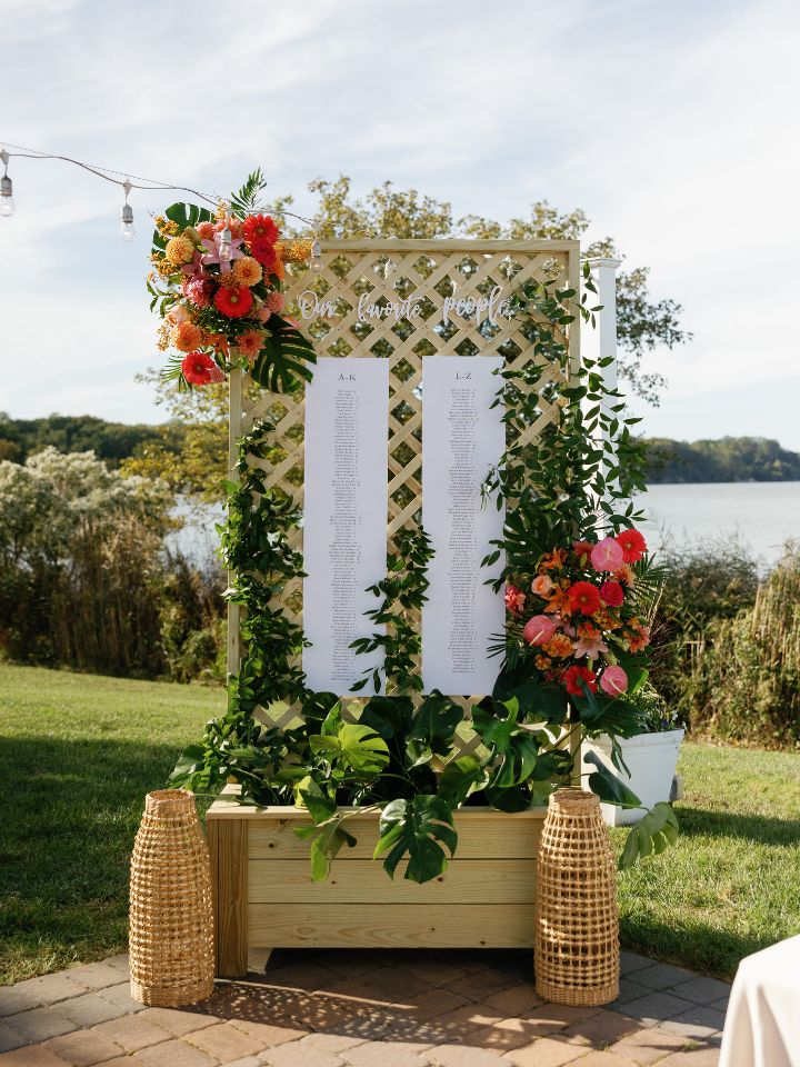 Seating chart with tropical flowers and ruscus greenery.