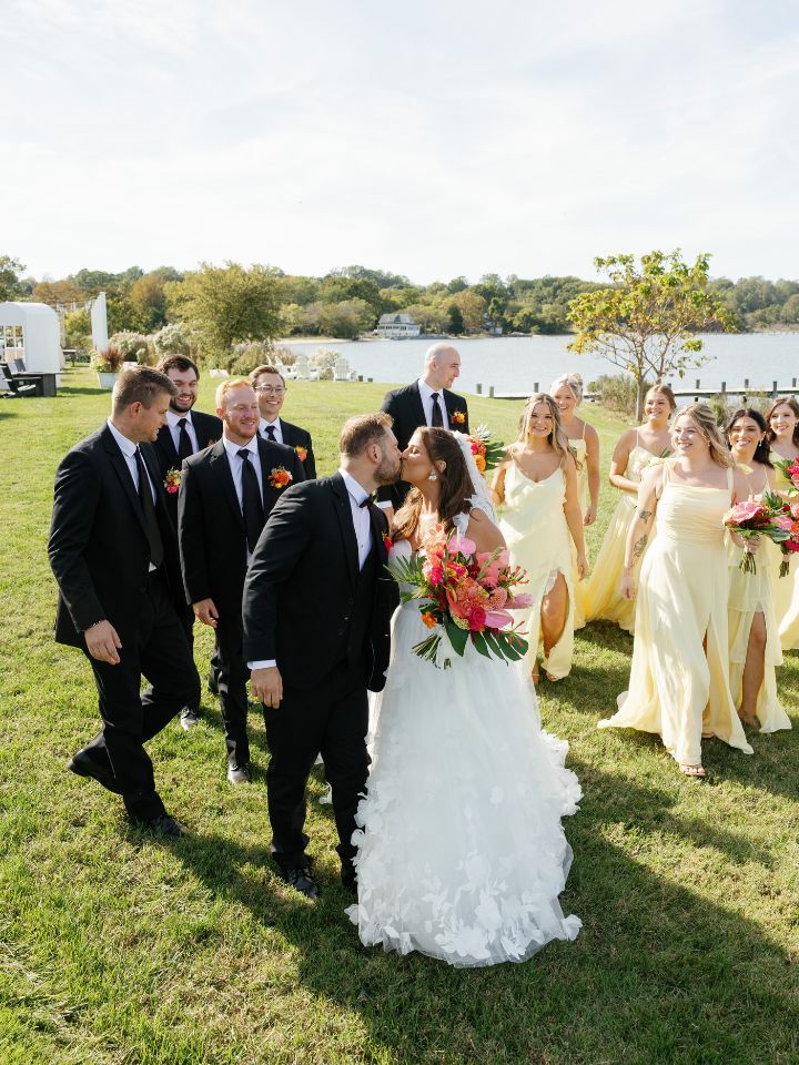 Bride and groom walk with wedding party.