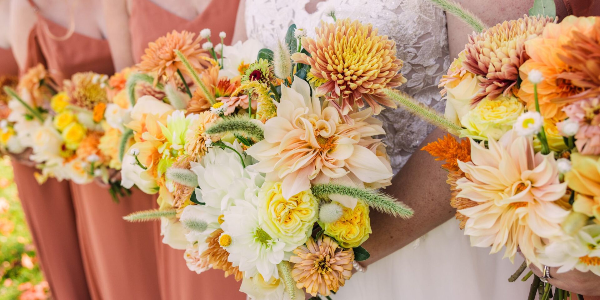 Bridesmaids lined up holding autumn harvest color palette bouquets.