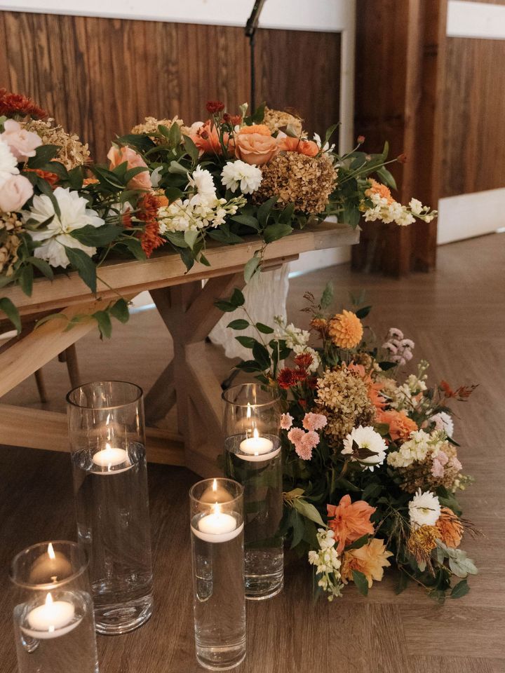 Detail of sweetheart table with candles and flower arrangements.
