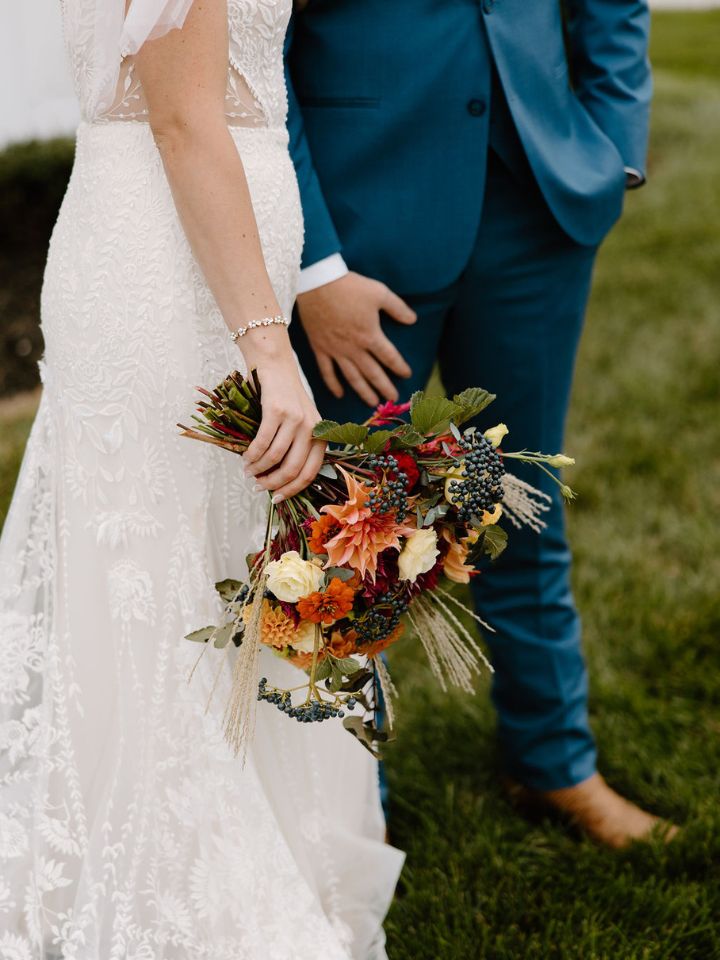 Bride and groom walk, while carrying her bouquet by her side.