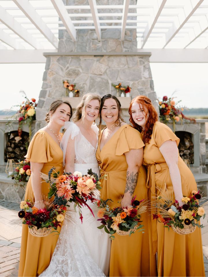 Bride and bridesmaids in mustard gold dresses.