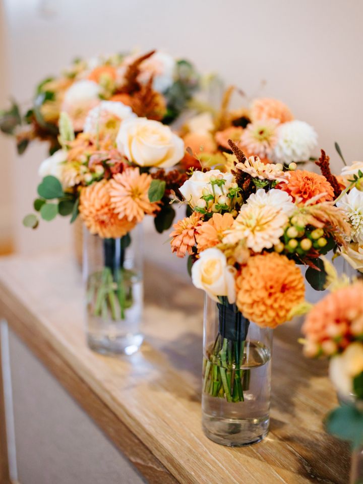 Bridesmaid bouquets lined up in vases.