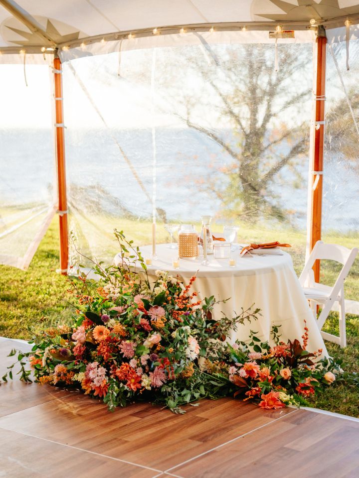 Fall wedding sweetheart table with lots of autumn flowers.
