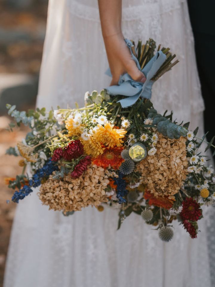 Bride holds her bouquet down by side.