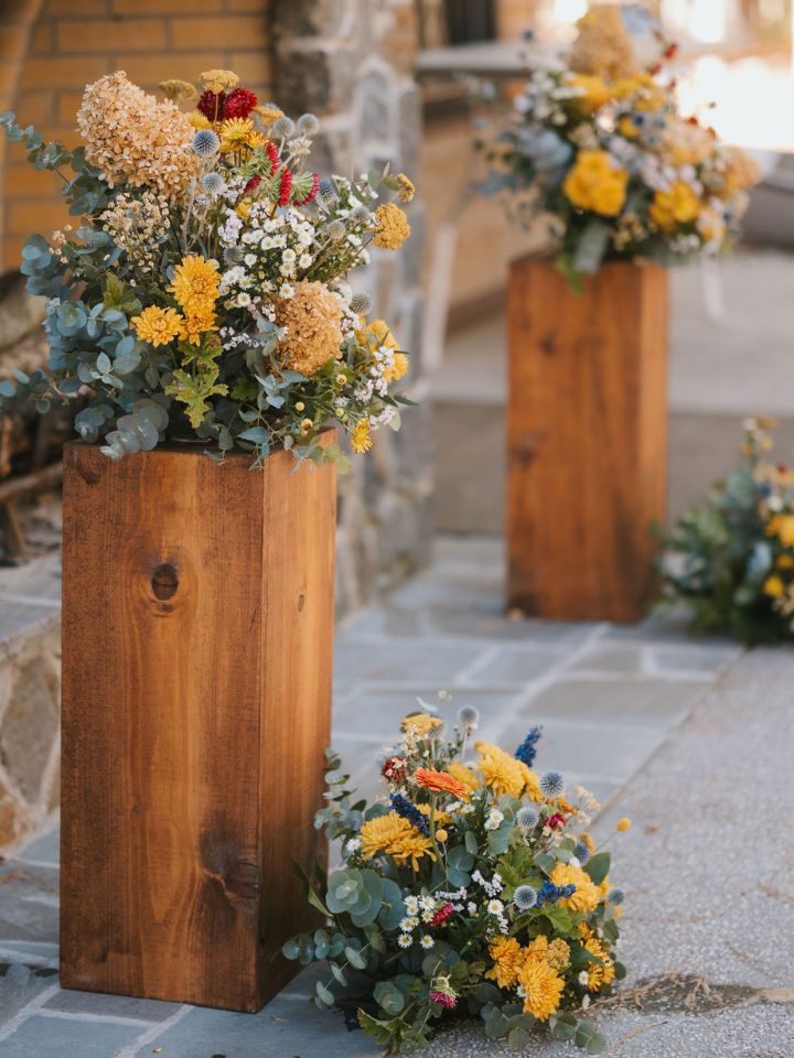 Ceremony flowers with wooden pedestals.