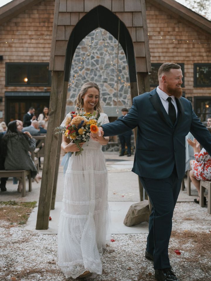 Bride and groom walk back down aisle after ceremony.