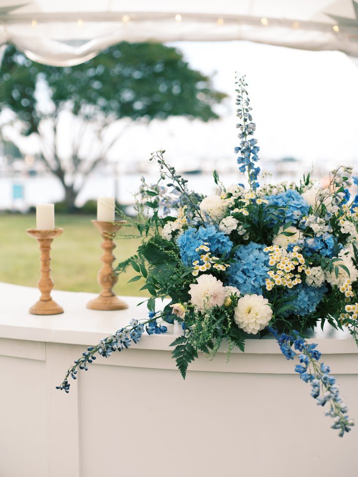 Flower arrangement for outdoor wedding reception bartop.