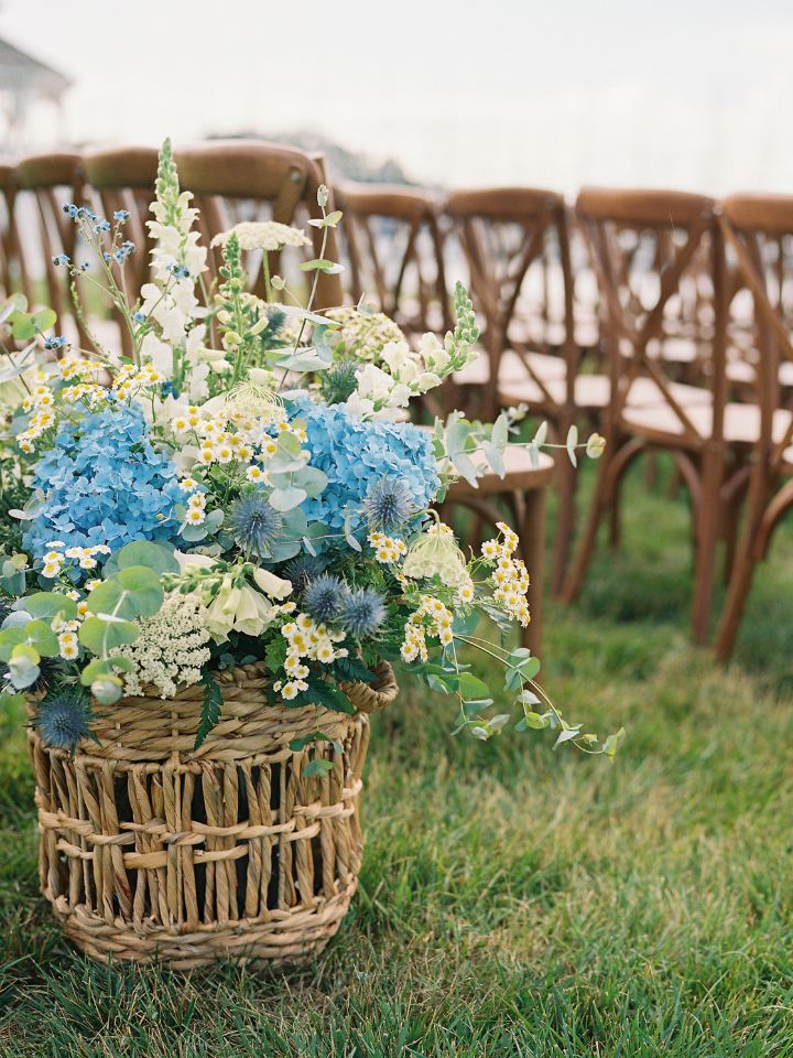 Large wicker basket with blue and white flower arrangement.