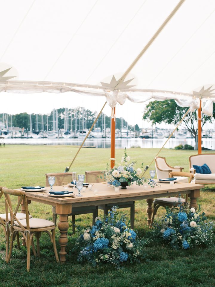 Harvest wood sweetheart table with blue and white flowers.