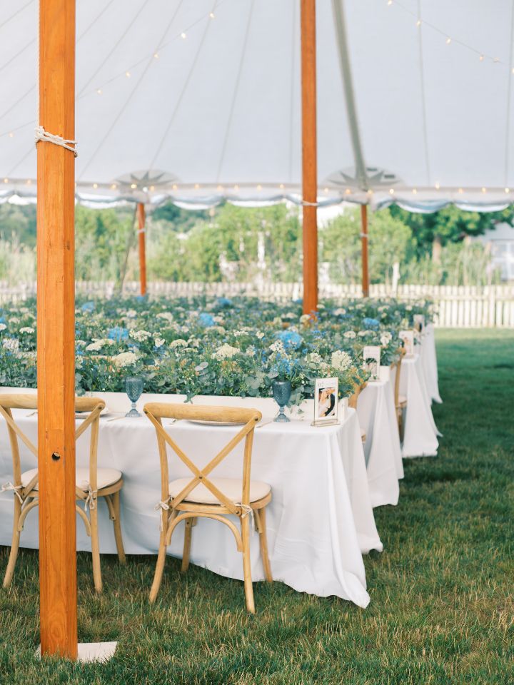 View of long reception tables in a line, with long flower arrangement runners on each.