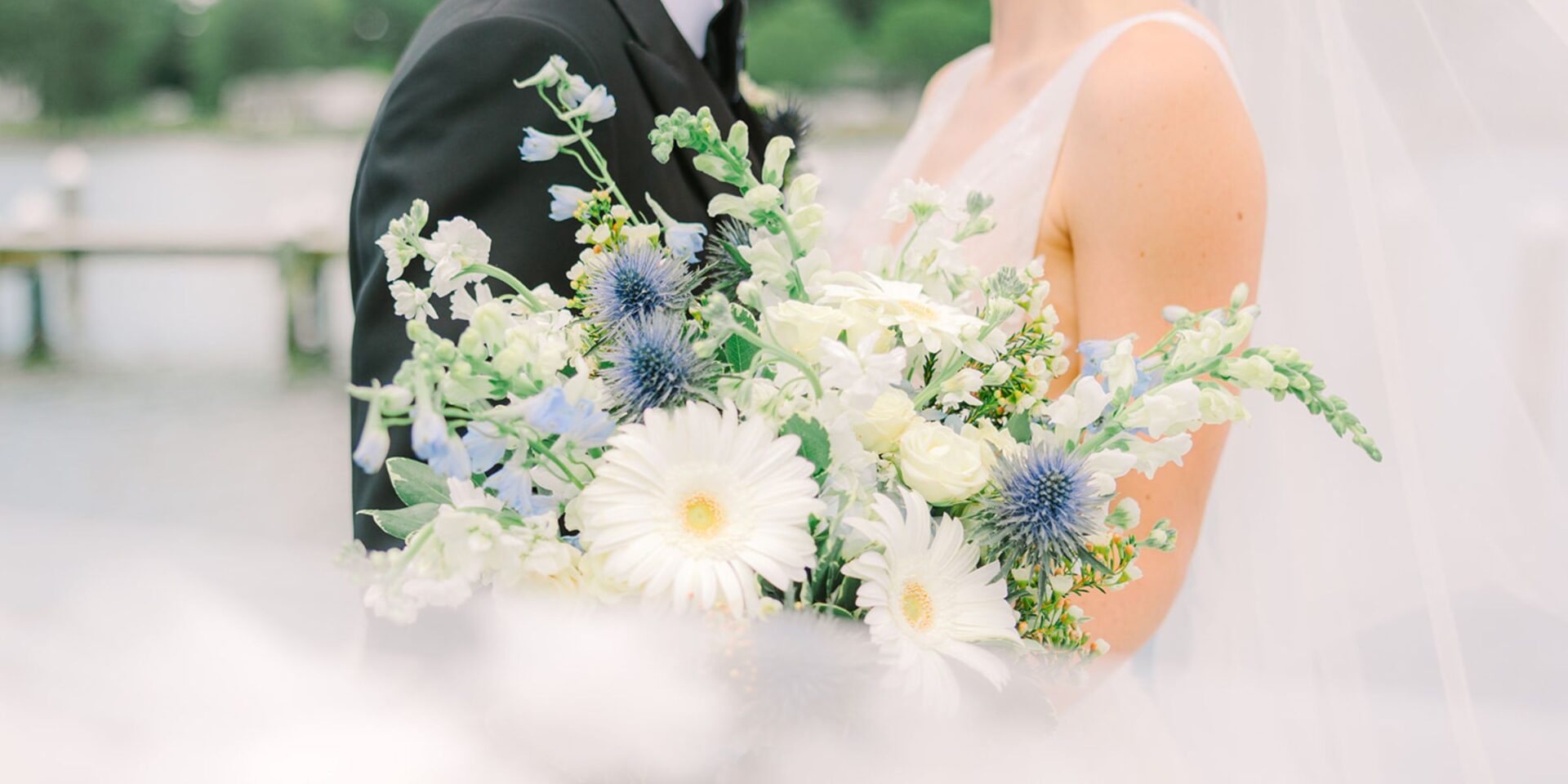 Blue and white bridal bouquet in a veil swirl.