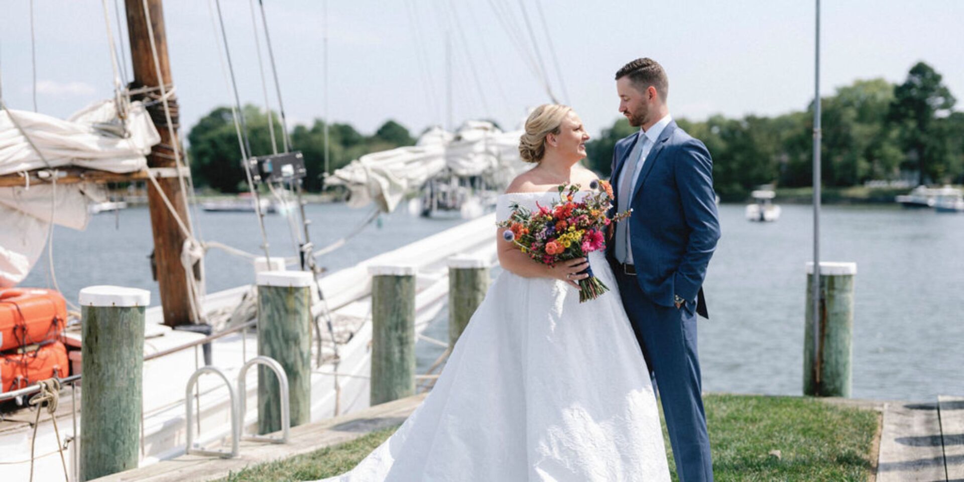 bride and groom smile at each other at waterfront wedding.