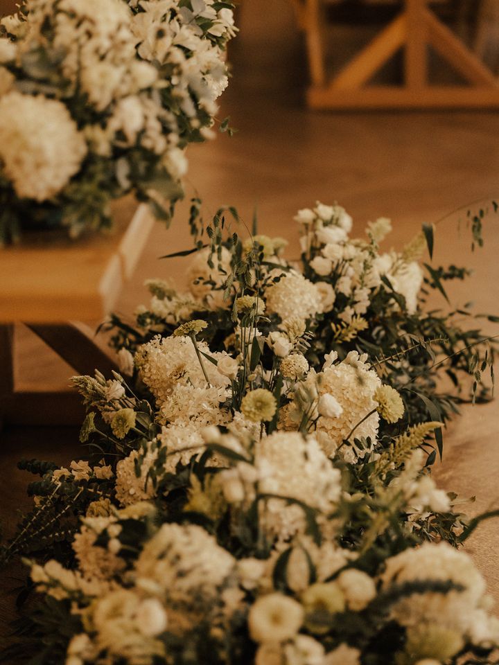Closeup of large flower arrangements at sweetheart table.