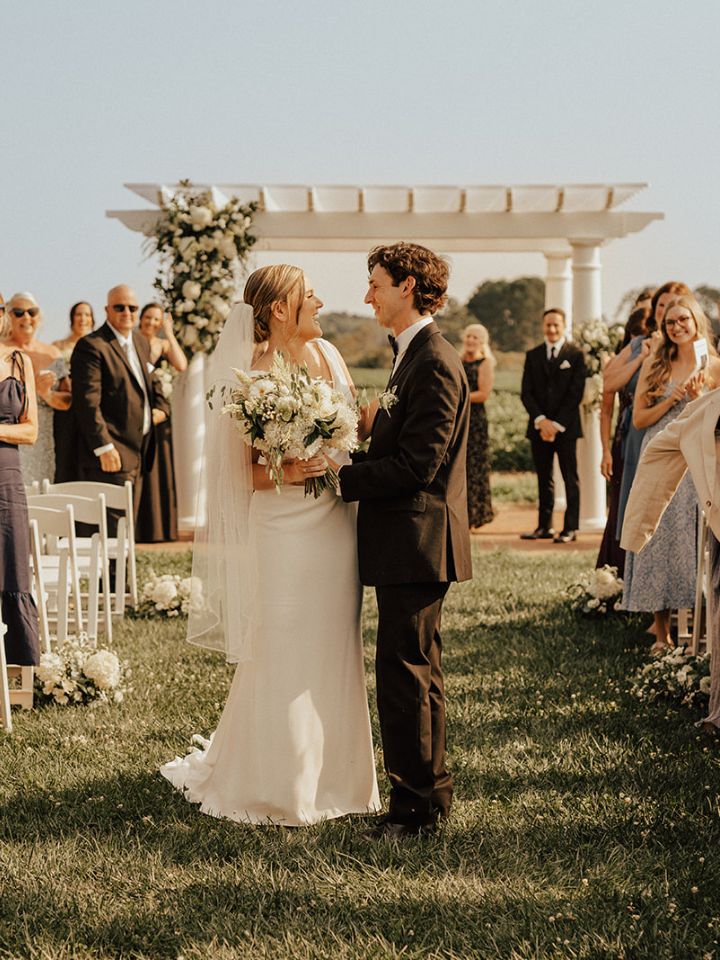 Bride and groom walk back down aisle after wedding ceremony.