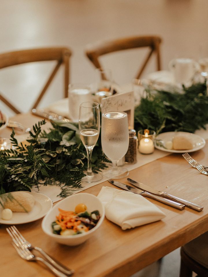 Greenery garland on table at wedding reception.