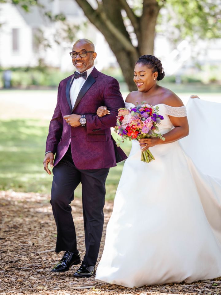 Bride and her father walk down the aisle at outdoor wedding ceremony.