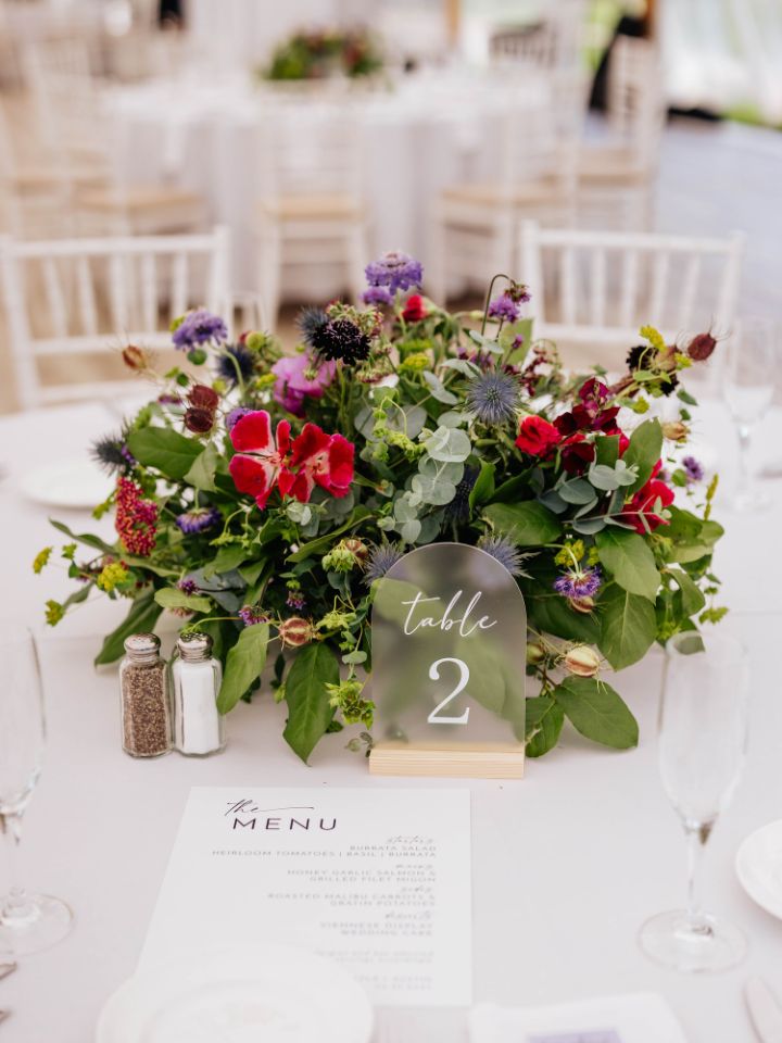 Round flower arrangement centerpiece on white table linen.