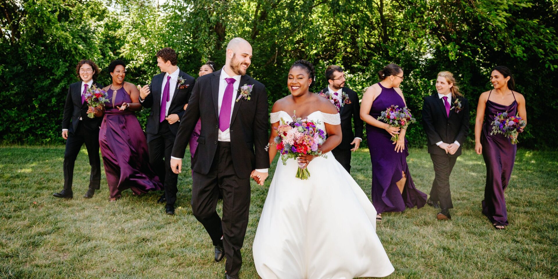 Bride and groom walking in front of wedding party.
