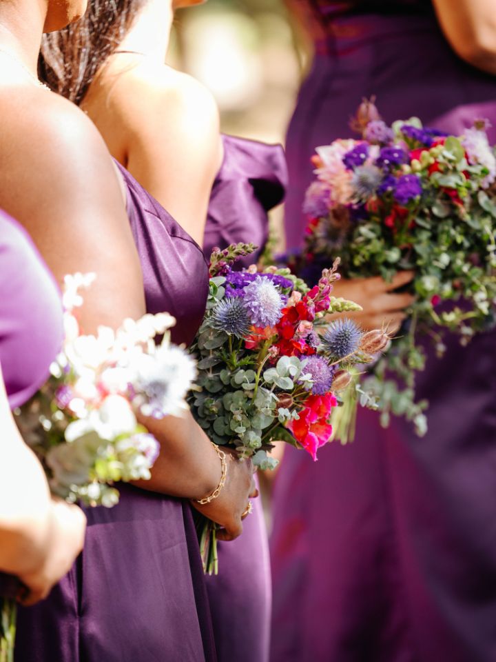 Closeup of bridesmaid bouquets while they stand in line at wedding ceremony.