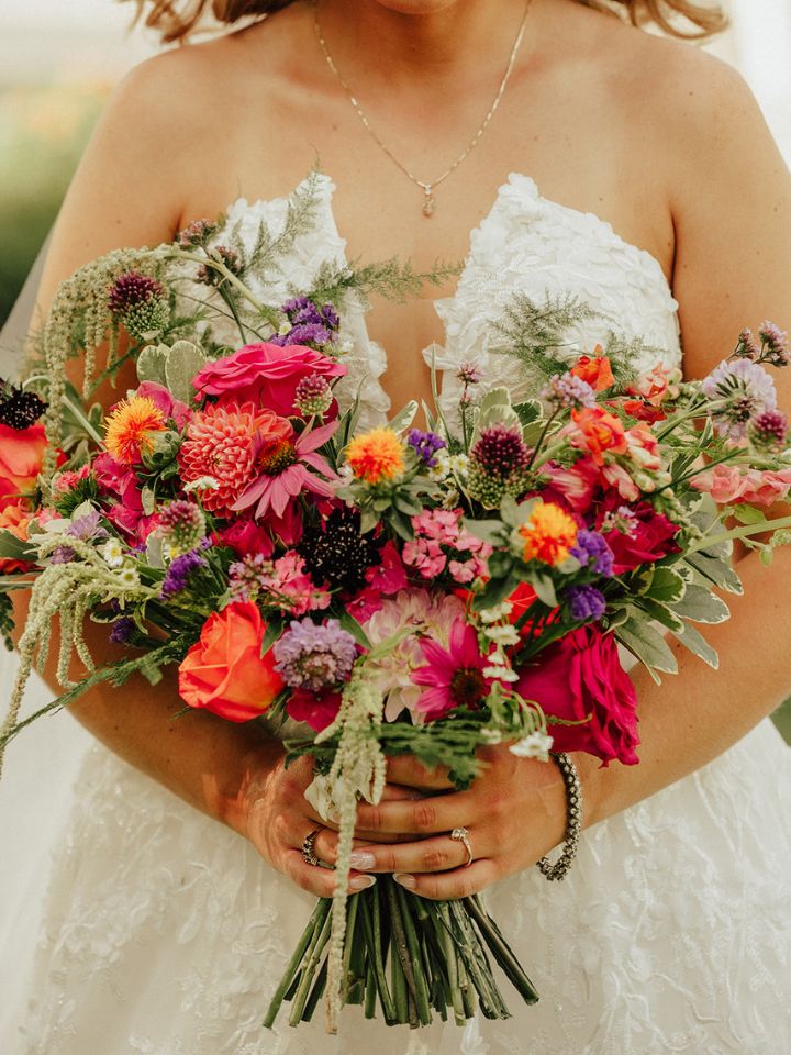 Closeup of bridal bouquet, in pinks, orange, purple, and green.