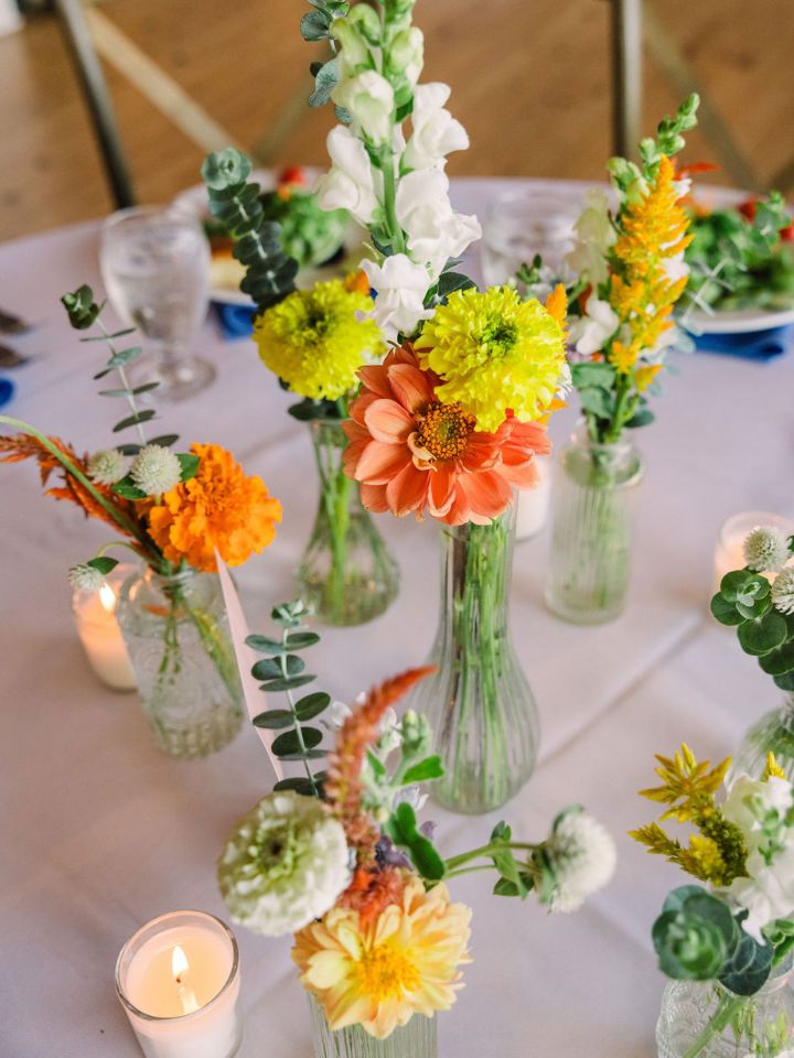 Summer flowers in bud vases, grouped together.