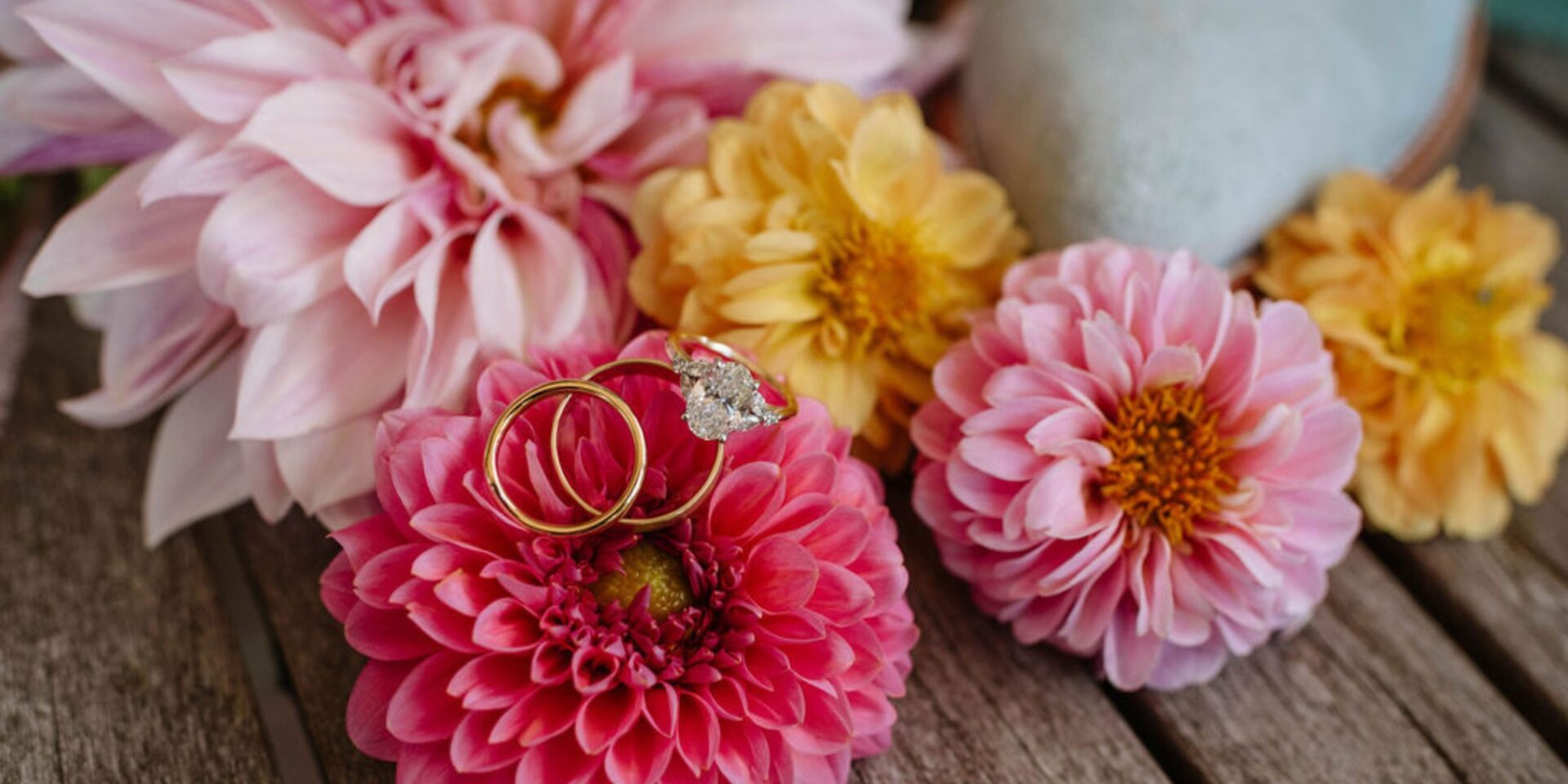 Detail shot of pink and yellow dahlias with engagement ring.