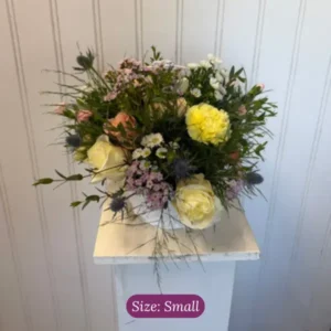 Small funeral basket arrangement in soft colors by wildly native flower farm