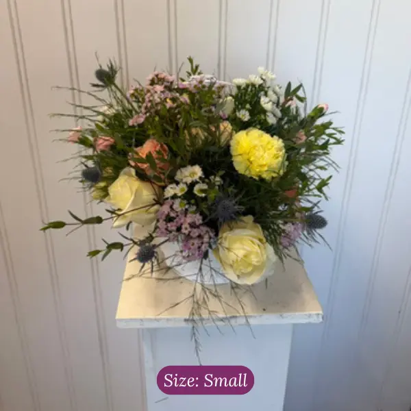 Small funeral basket arrangement in soft colors by wildly native flower farm