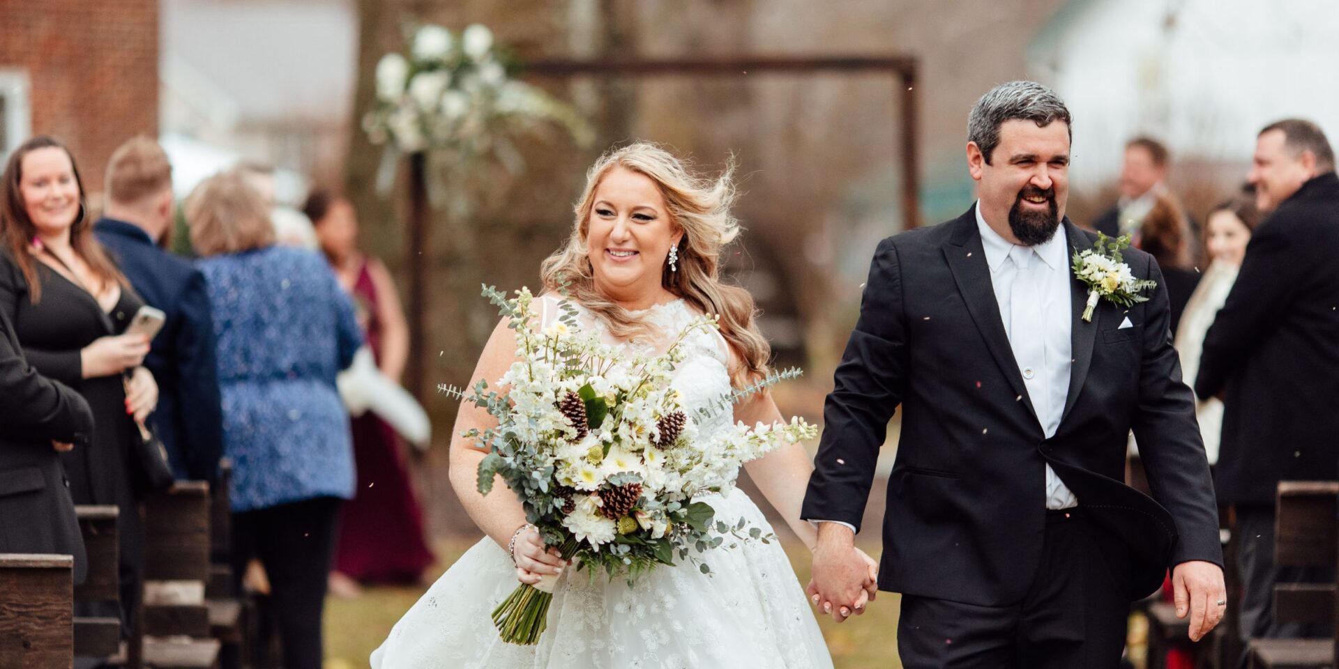 Bride and groom walk back down aisle after wedding ceremony.