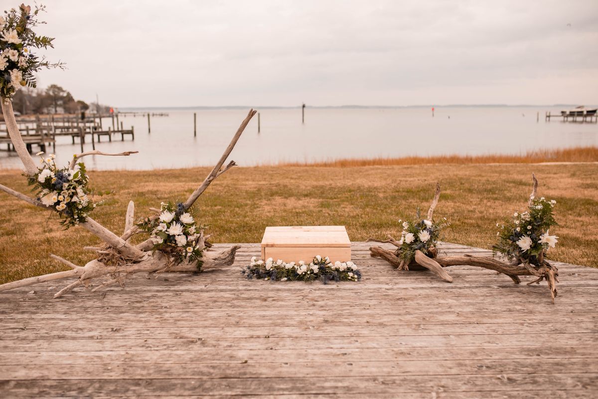Driftwood with flower arrangements for a wedding ceremony backdrop.