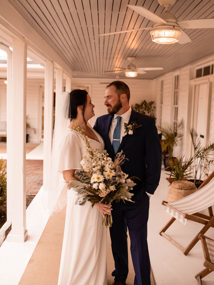 Bride and groom pose on deck of Wylder Hotel Tilghman Island.